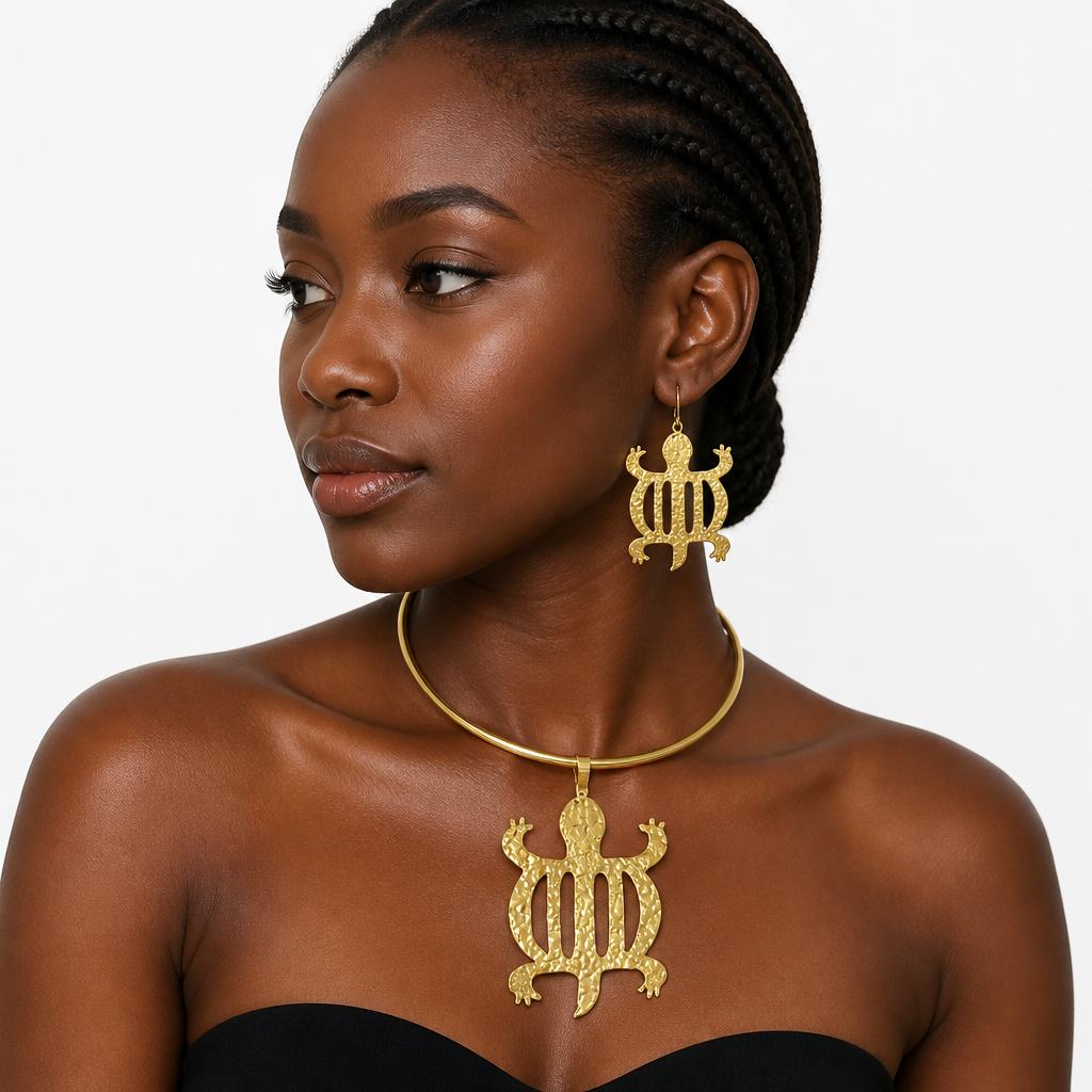 A woman wearing a gold necklace and matching drop earrings with a textured turtle design, shown against a plain light gray background.