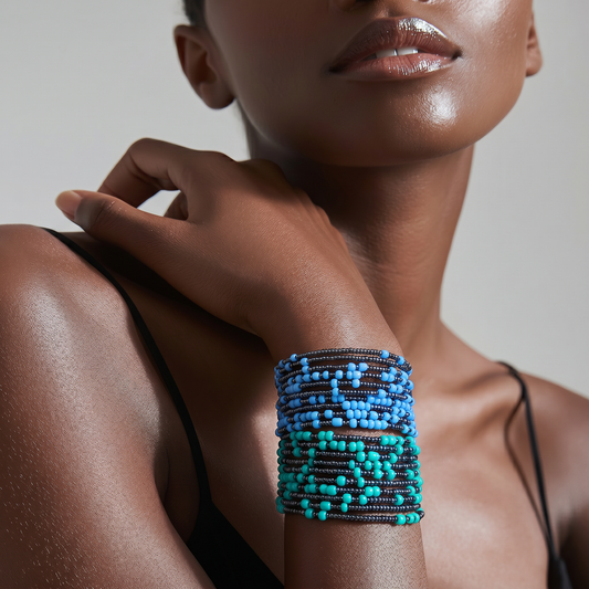 A close-up of a model wearing a wide, multi-strand beaded cuff bracelet on her wrist. The bracelet features rows of dark brown beads, light blue beads, and turquoise beads.